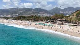 Alanya'da güneşli havayı fırsat bilen yerli ve yabancı turistler dünyaca ünlü plaja akın etti