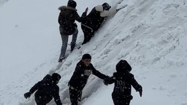 Hakkari Yüksekova'da tepsiler kızak oldu, karlı yamaçlar oyun alanına dönüştü