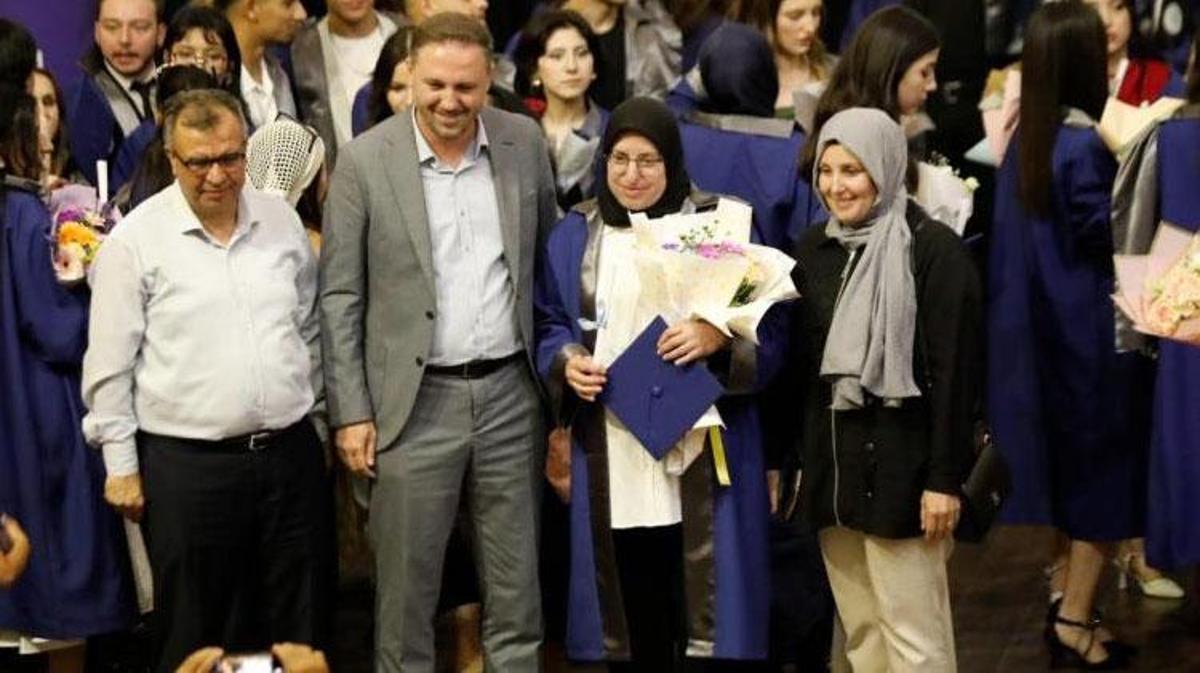 Kadriye Ülke, elinde diplomasıyla gülümserken