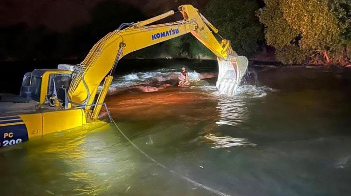 Baraj sularının yükselmesi sonucu mahsur kalan gencin iş makinesiyle kurtarılma anı.