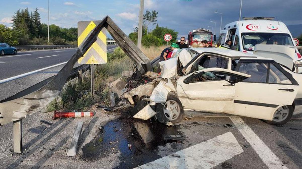 Anadolu Otoyolu'nda meydana gelen trafik kazasında bariyerlere çarpan otomobilden yaralıların çıkarılması.