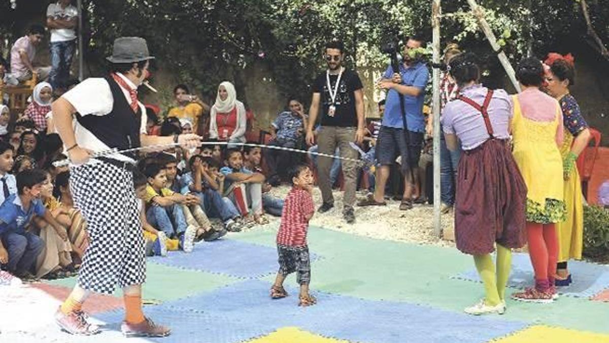 Savaştan kaçan çocukları güldürüyorlar