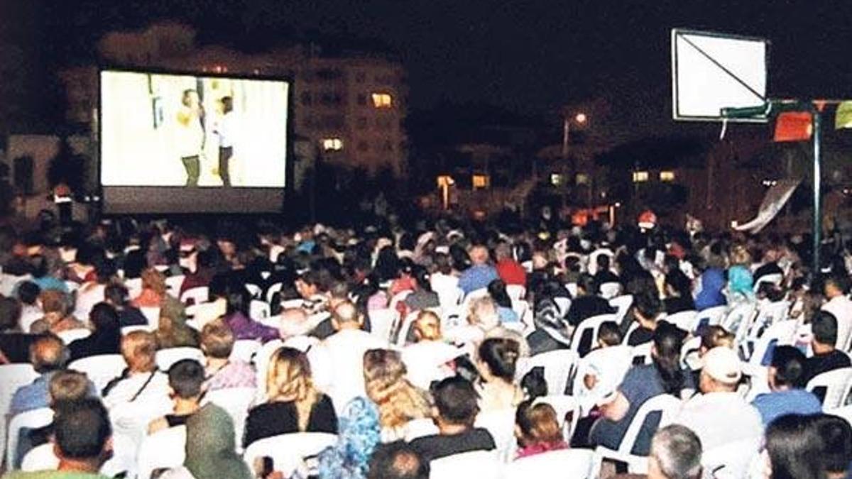 Evinin bahçesini çocuklara sinema yaptı