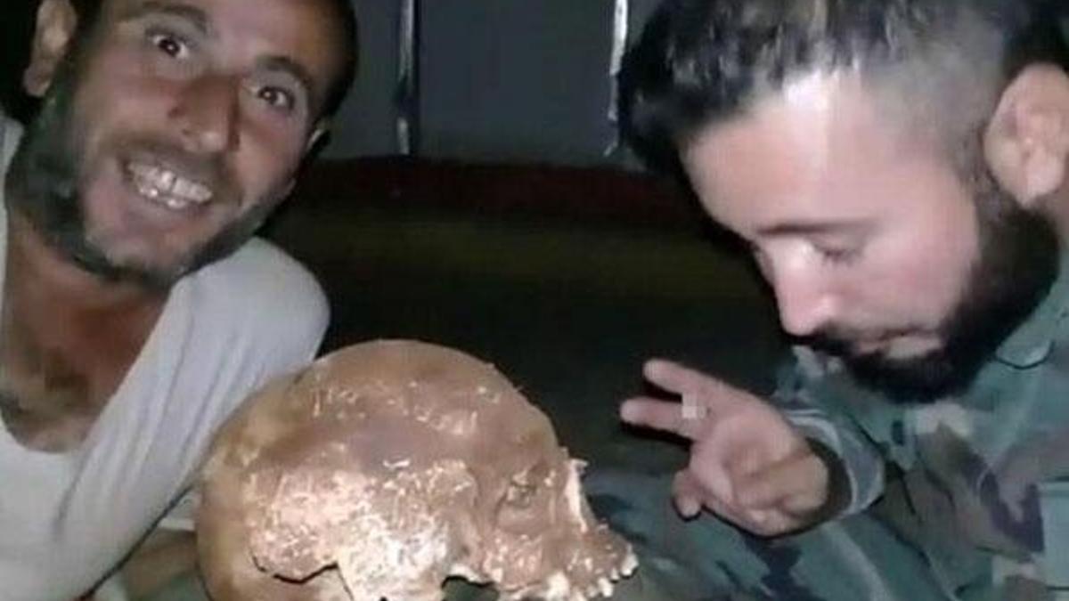 Esed rejimi askerleri mezardan kafatası çıkartıp fotoğraf çekti