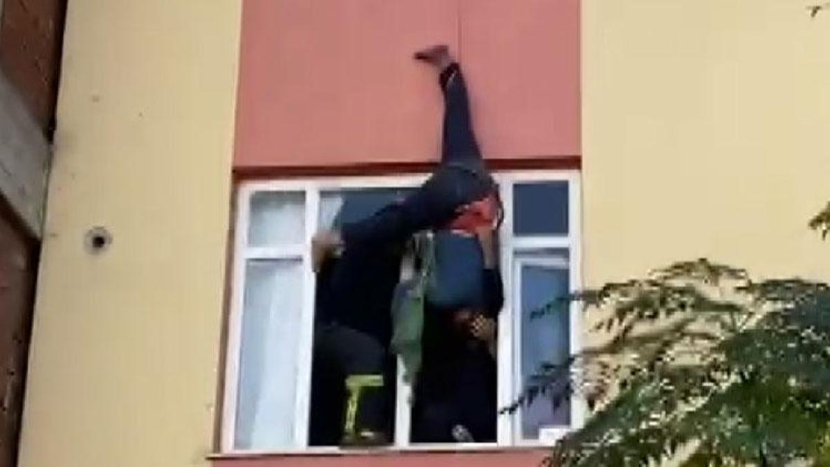 İçeride anahtarını unuttuğu dairesine çatıdan halatla sarktı, asılı kaldı