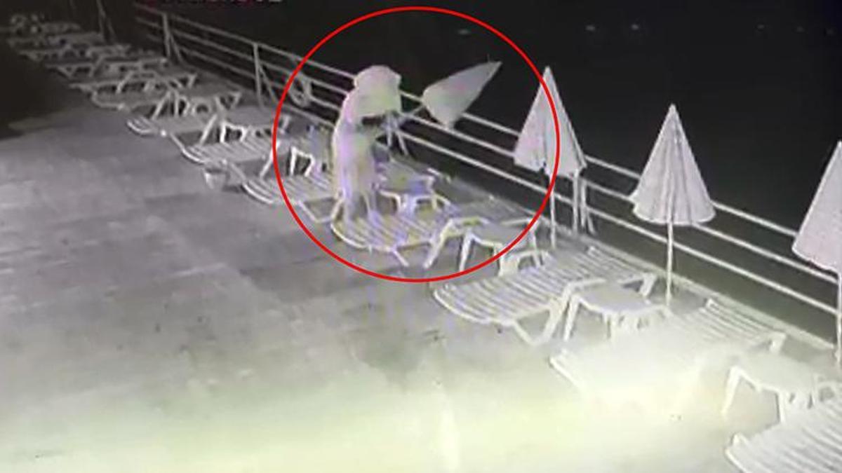 Havluyla yüzünü gizleyip dans etti, sonra plaj şemsiyelerini denize attı