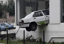 Kaldırıma çarpıp havalanan otomobil, binada asılı kaldı