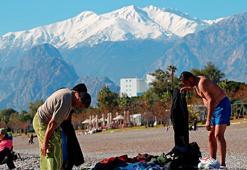 Antalyalı vatandaşlar yılın ilk gününü karlı dağların gölgesinde güneşlenerek geçirdi