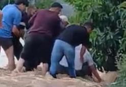 Yolun karşısına geçerken sele kapılan şahsı mahalle sakinleri kurtardı