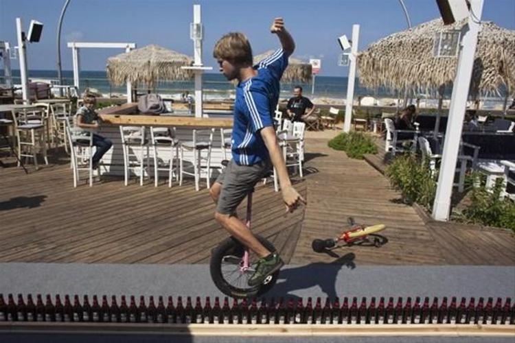 Alman Lutz Eichholz tek tekerlekli bisikletiyle 8.93 metre uzunluğunda 127 bira şişesinin üzerinden geçiyor