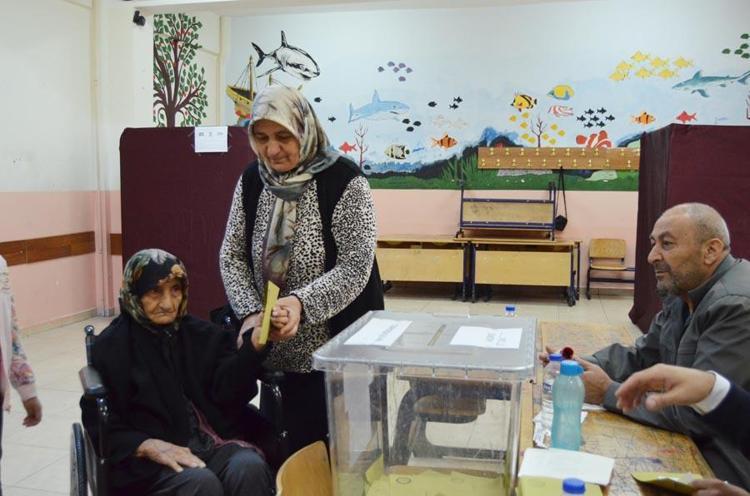 115 YAŞINDA TEKERLEKLİ SANDALYEYLE GETİRİLDİĞİ OKULDA OY KULLANDI