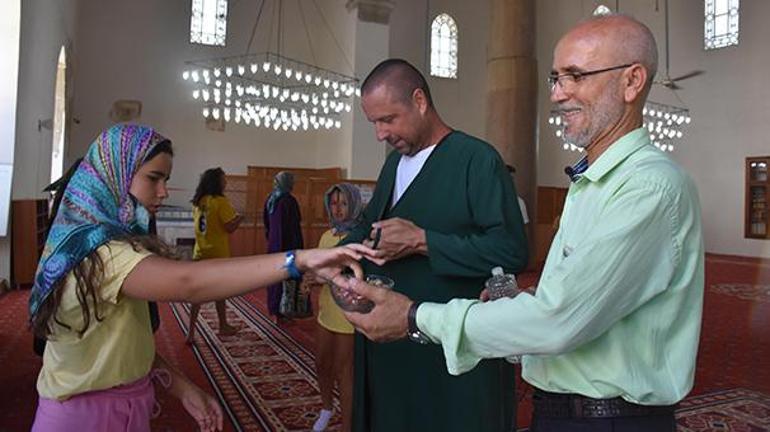 İzmirdeki cami imamı gündem oldu Turistlerle İngilizce sohbet edip hediye veriyor