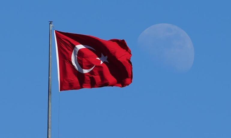 Mavi gökyüzünde dalgalanan Türk bayrağı ve ay manzarası