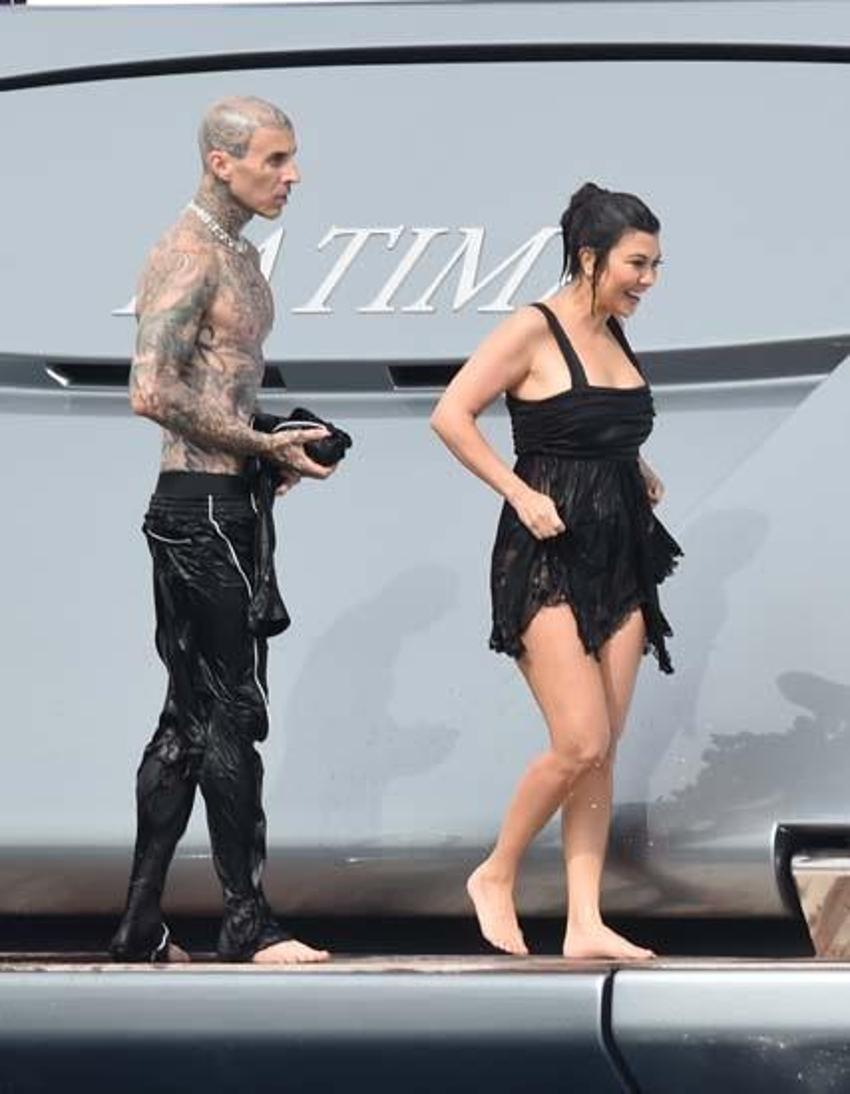  Kourtney Kardashian ve Travis Barker balayına çıktı! Elbiselerle denize atladılar...
