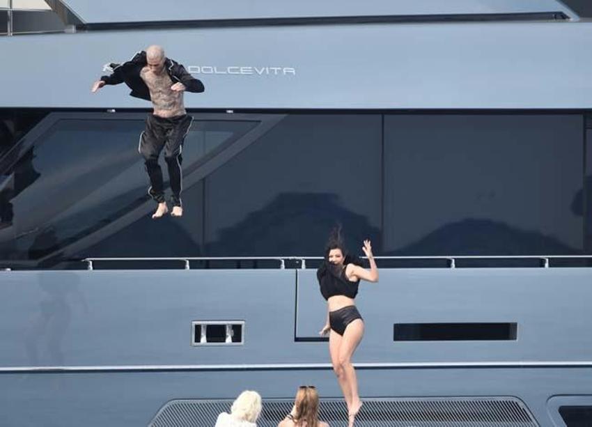  Kourtney Kardashian ve Travis Barker balayına çıktı! Elbiselerle denize atladılar...