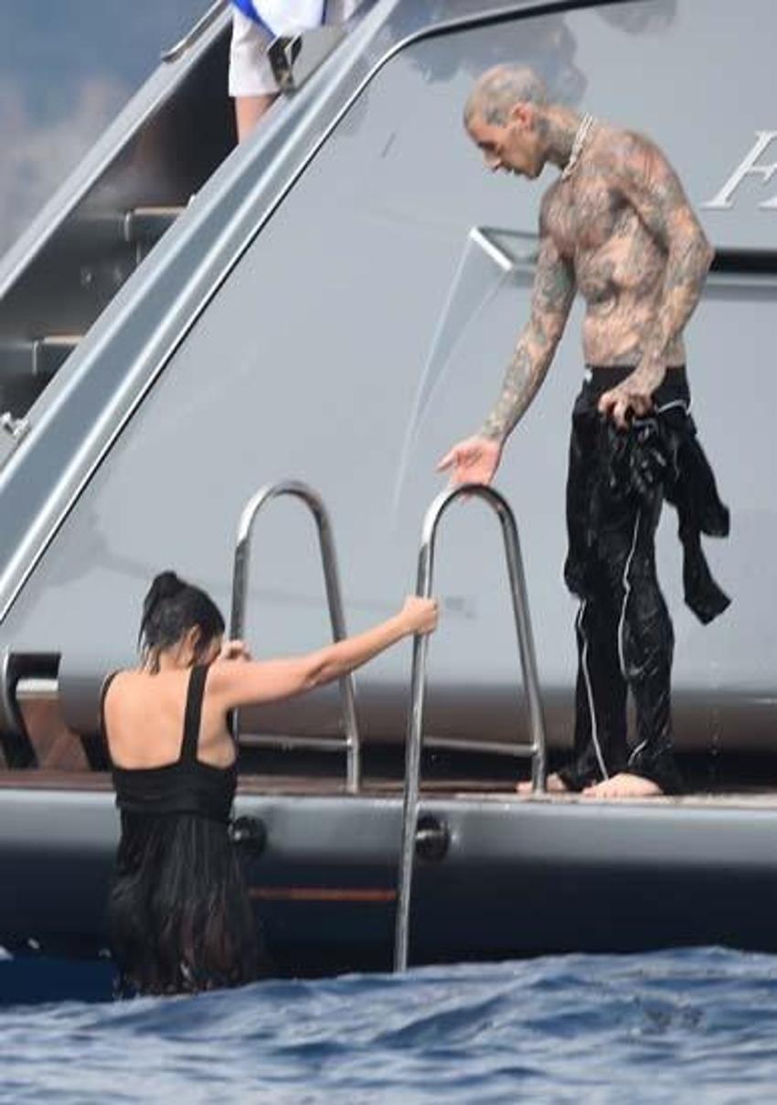  Kourtney Kardashian ve Travis Barker balayına çıktı! Elbiselerle denize atladılar...