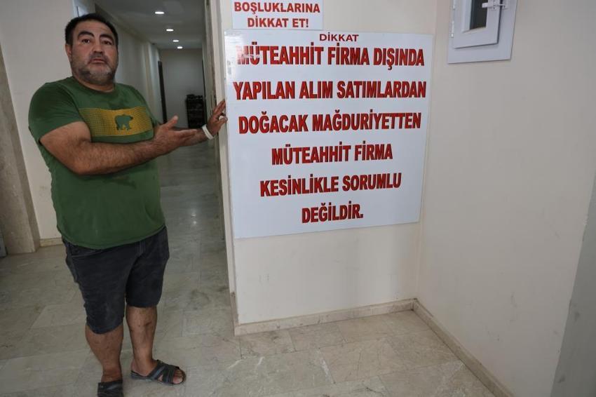 Dolandırıldığını söyleyen müteahhit dairenin kapısını betonla kapattı, binaya afiş astı