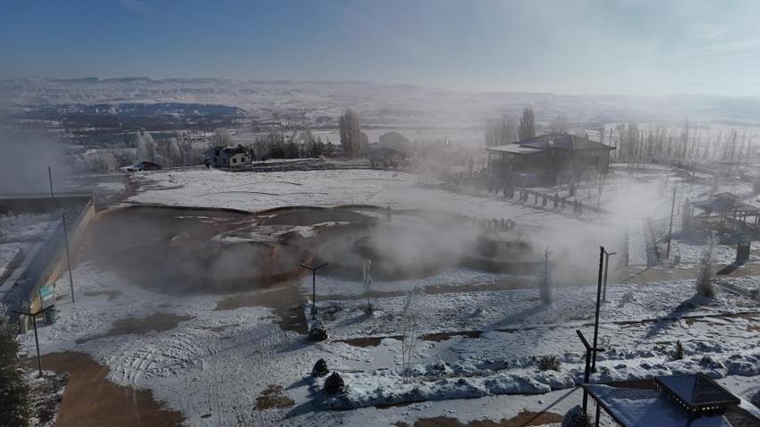 Sivas'ın dondurucu soğuğunda bir kedi donmamak için termal suyun yanında ısındı