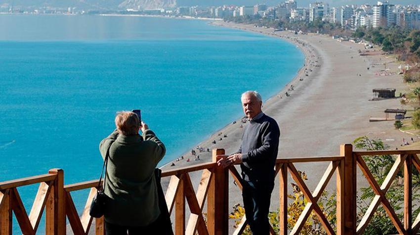 Antalyalı vatandaşlar yılın ilk gününü karlı dağların gölgesinde güneşlenerek geçirdi