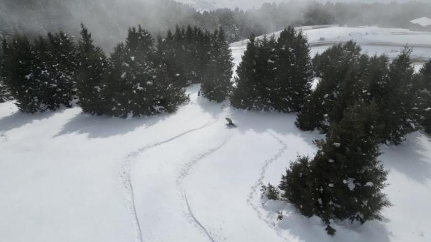 Kümbet Yaylası'nda ilkbaharda yağan karda snowboard keyfi yaşadılar