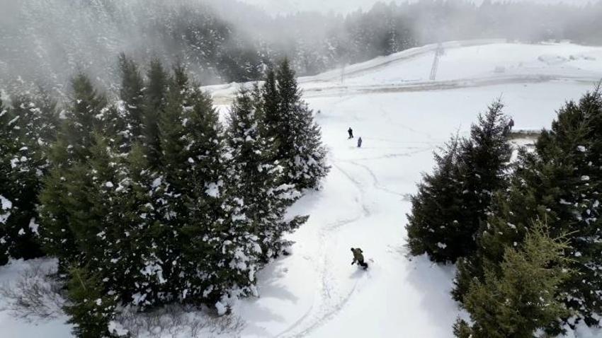 Kümbet Yaylası'nda ilkbaharda yağan karda snowboard keyfi yaşadılar