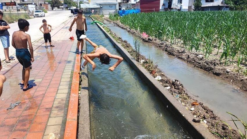 Adana sıcağına çocukların çözümü basit oldu: Kaldırımı plaja çevirdiler