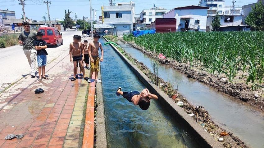 Adana sıcağına çocukların çözümü basit oldu: Kaldırımı plaja çevirdiler