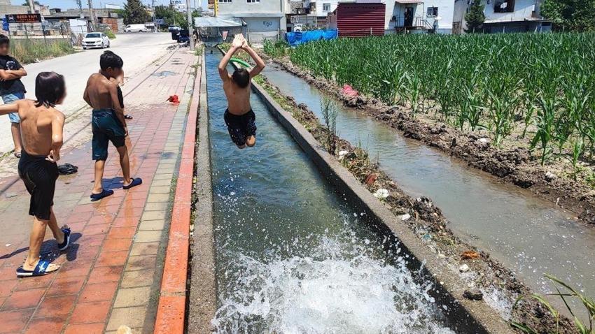 Adana sıcağına çocukların çözümü basit oldu: Kaldırımı plaja çevirdiler